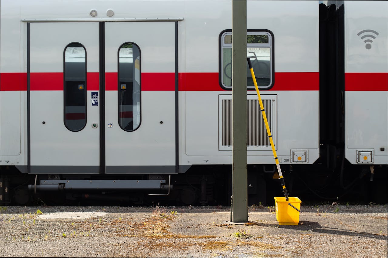Image of a modern train with cleaning equipment on standby outside.